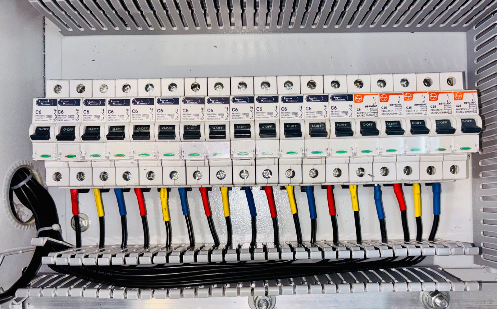 A consumer unit with neatly colour-coded wiring across a row of circuit breakers