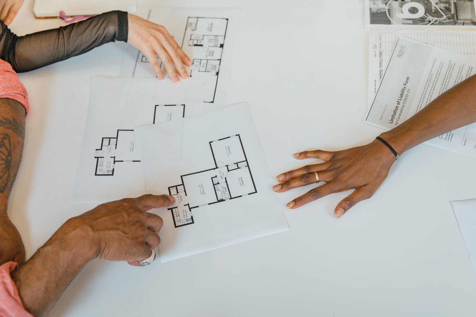 Two people looking over a floor plan spread across a table