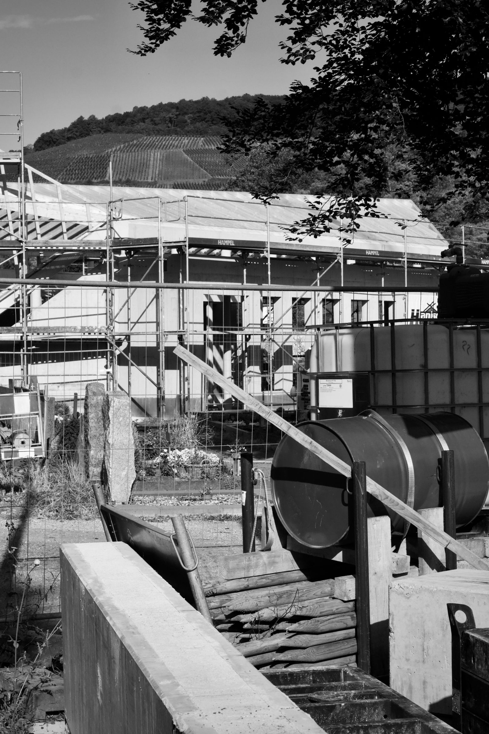 A building under construction, wrapped in scaffolding, in black and white