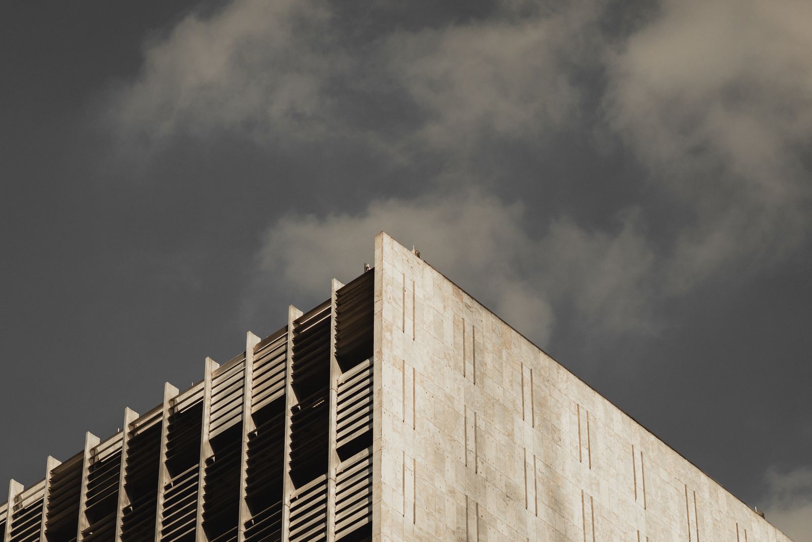 A concrete building standing against a heavy grey sky
