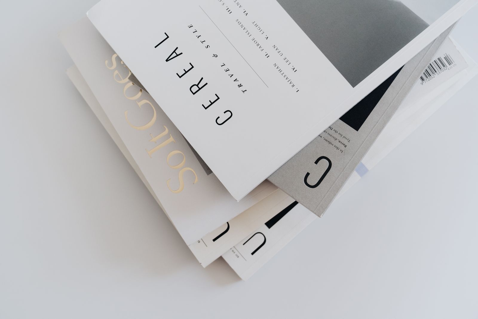A stack of magazines with restrained cover typography, shot from above