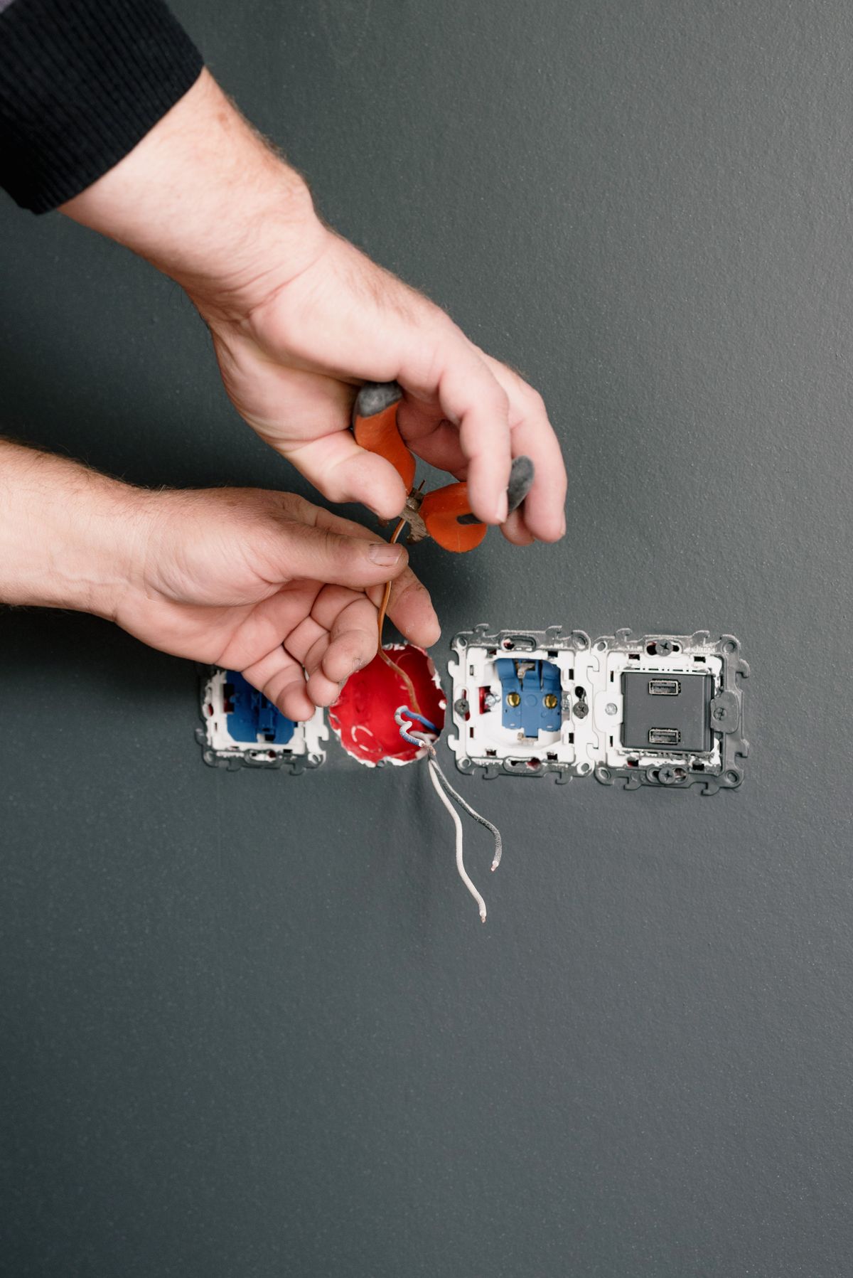 An electrician wiring a bank of sockets