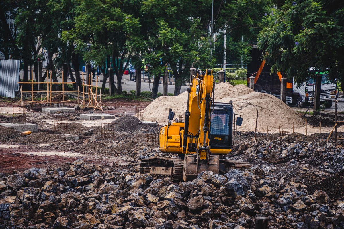 An excavator working over broken ground on a site