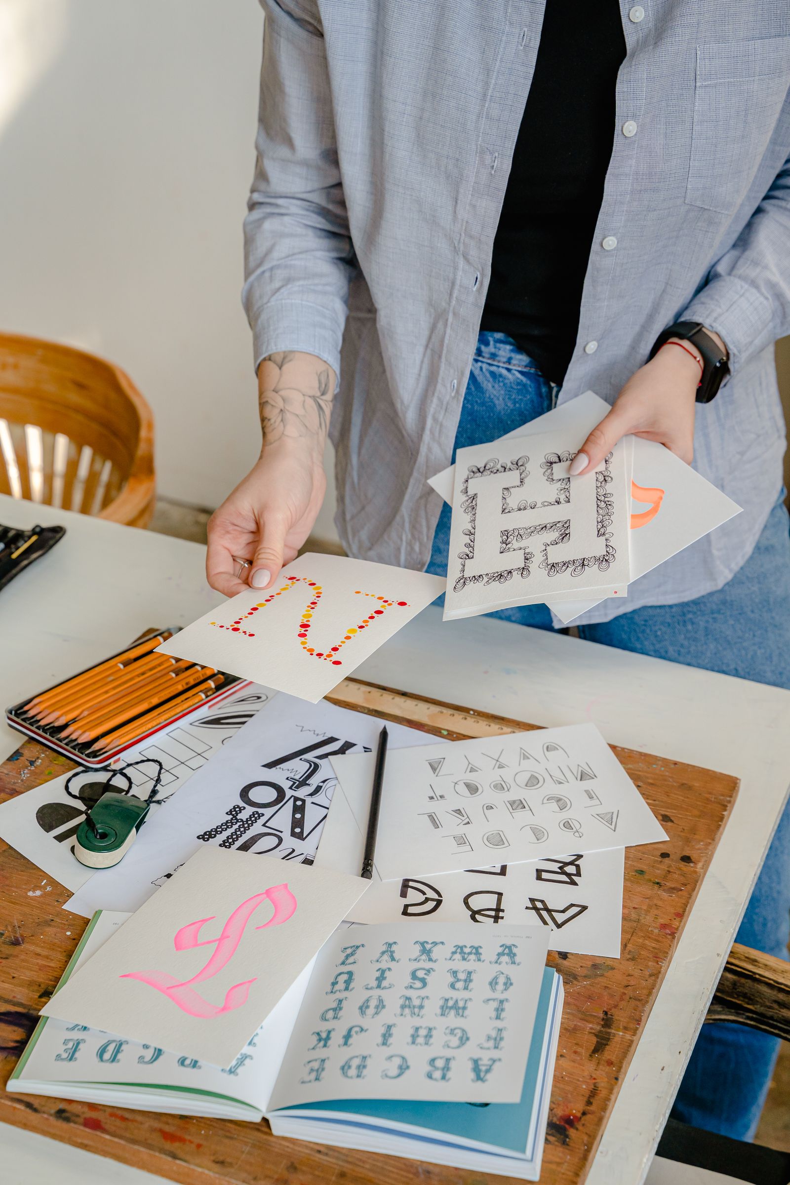 A studio desk with lettering studies, pencils and layout sketches